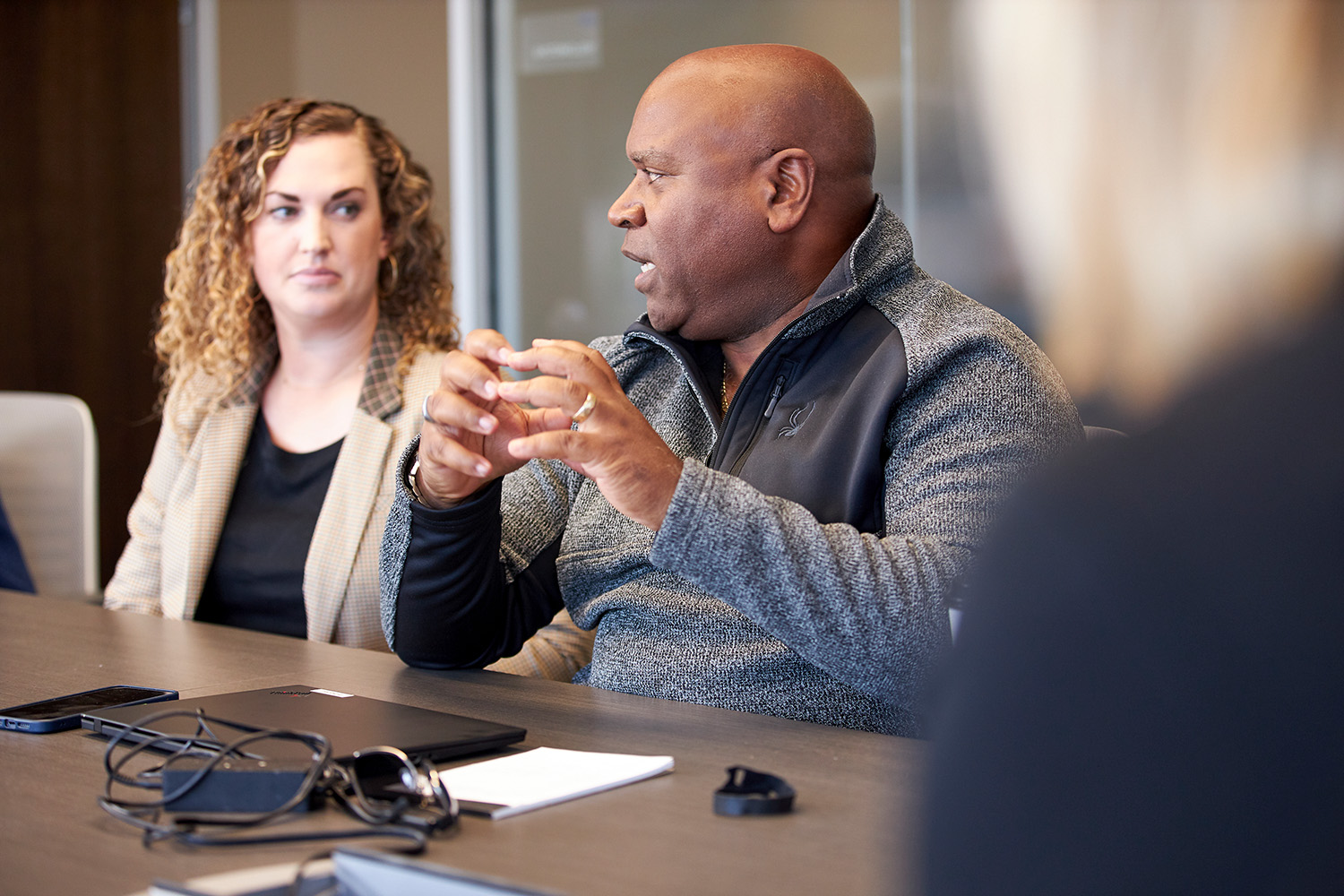 Two people engaged in discussion at a conference table.